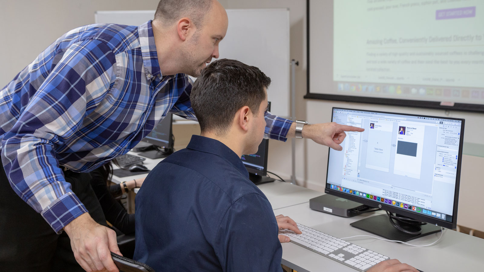 teacher showing something to a student in a classroom